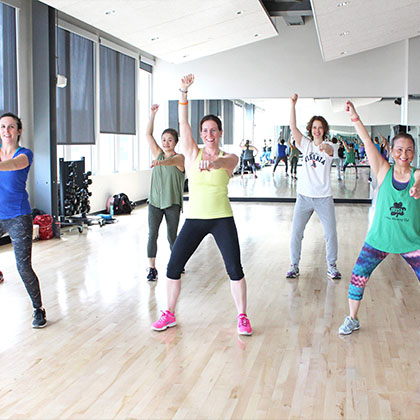 group of people doing zumba class in gym